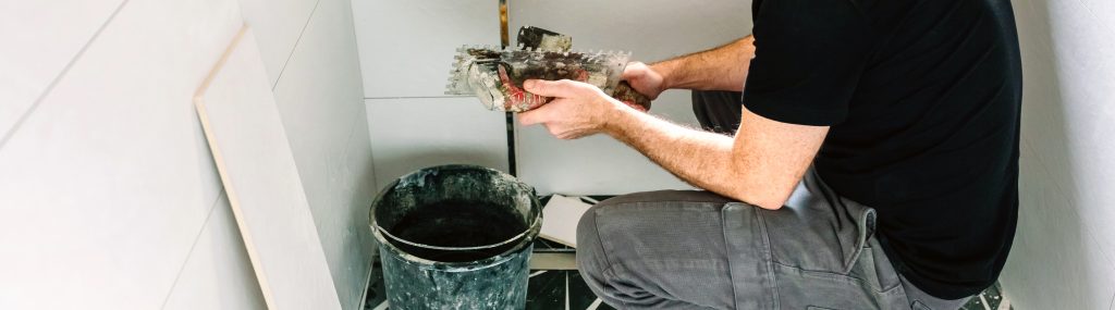 hombre arreglando el suelo del baño