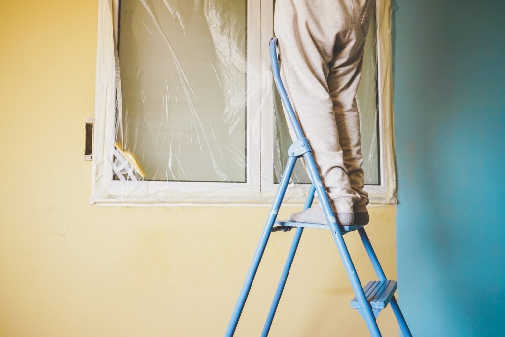hombre pintando su casa