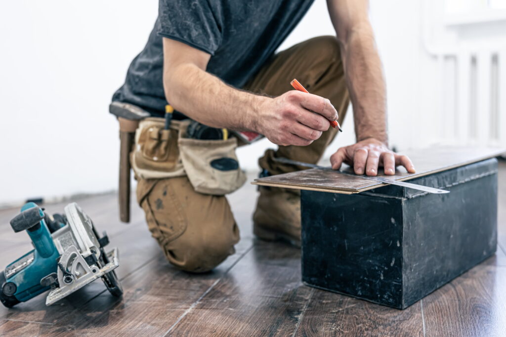 hombre cortando trozos de parquet