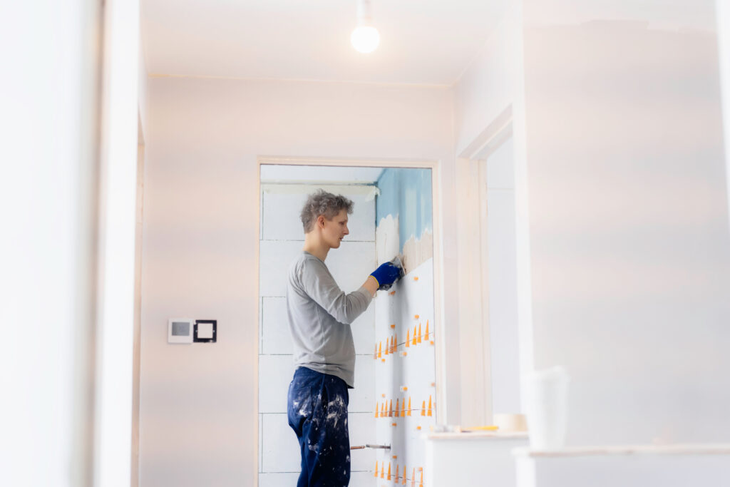 hombre instalando azulejos en el baño